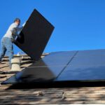 Solar Panels Roof - man in white dress shirt and blue denim jeans sitting on white and black solar panel