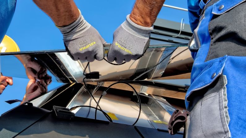 Solar Panels Comparison - two men carrying a metal sheet
