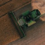Solar Equipment Tech - green farming equipment on brown field